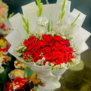 RED STATICE BOUQUET IN WHITE SHEETD ROSES AN